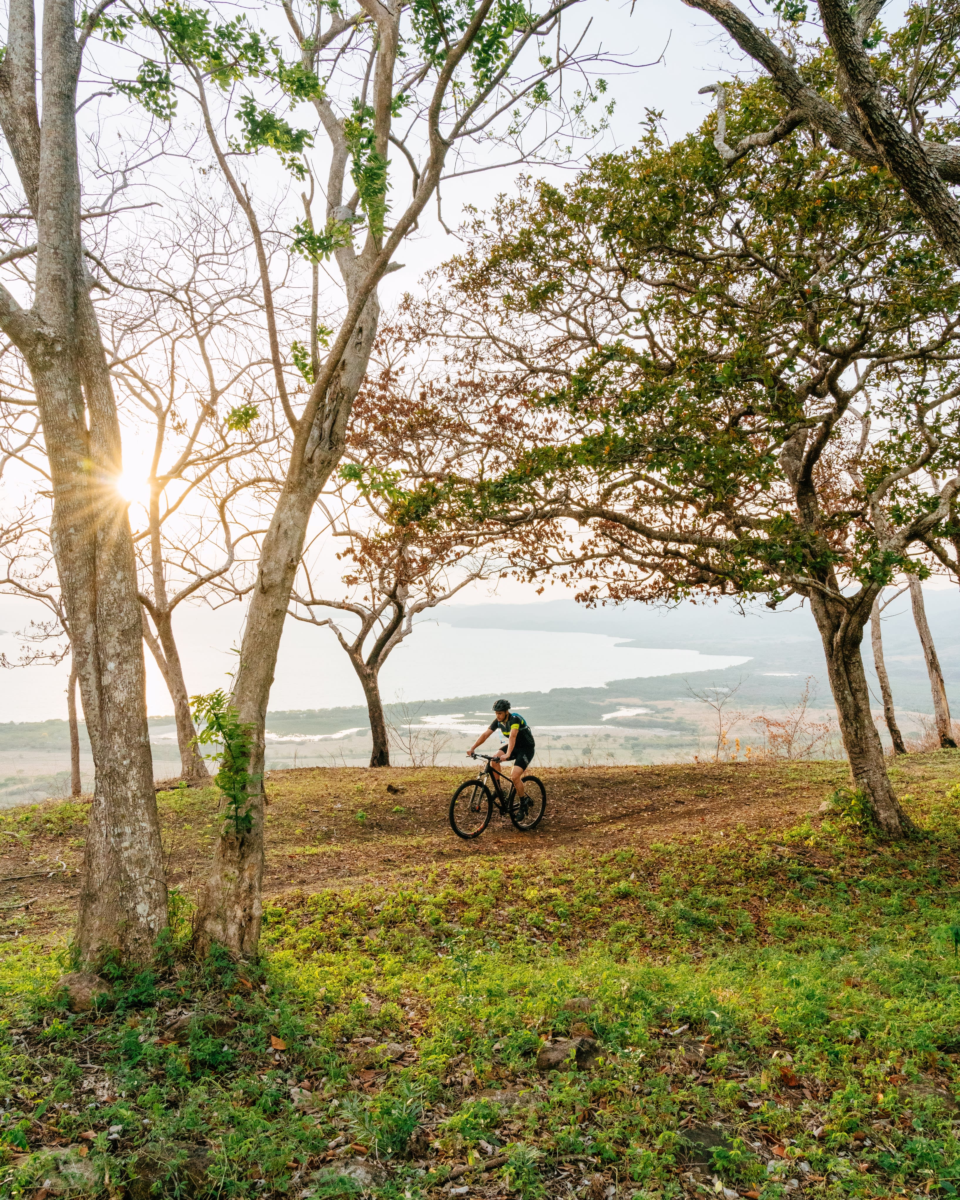 man riding a mountain bike on a trail called "el caminito al mar" or "the little trail to the sea"