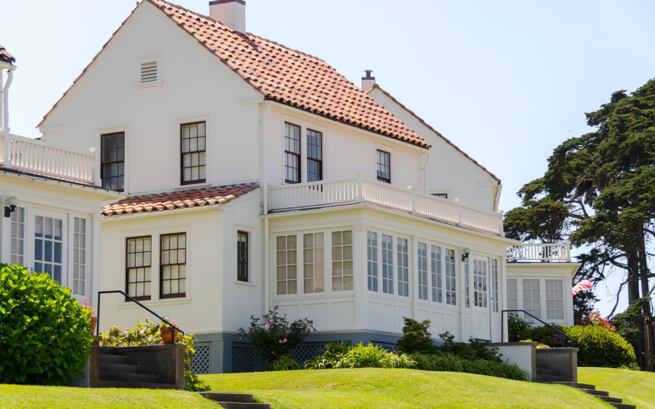 An elegant white house with a striking red roof creates a warm and welcoming ambiance.