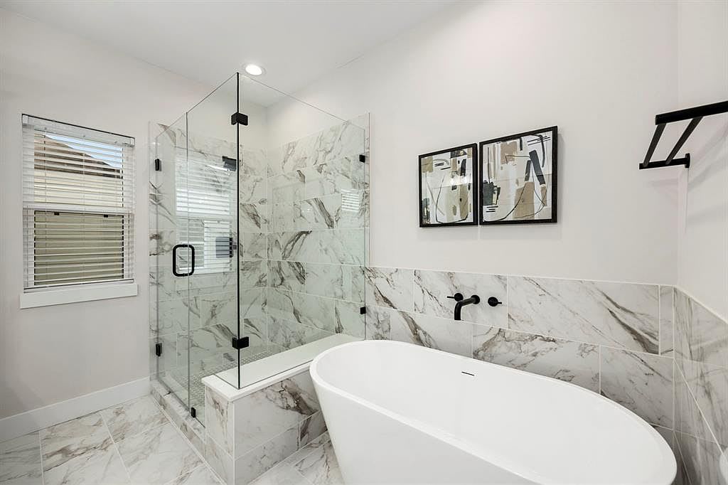 bathroom with a large tub and shower