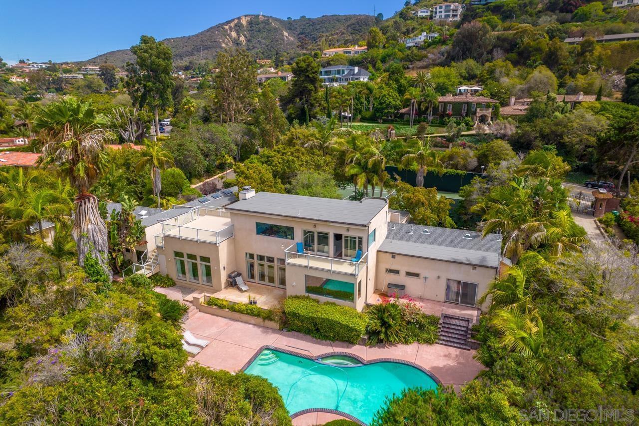 House with a pool surrounded with palm trees in Hidden Valley, La Jolla, California