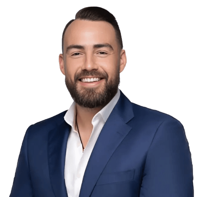 Smiling bearded man in a navy suit jacket and white shirt against a green background.