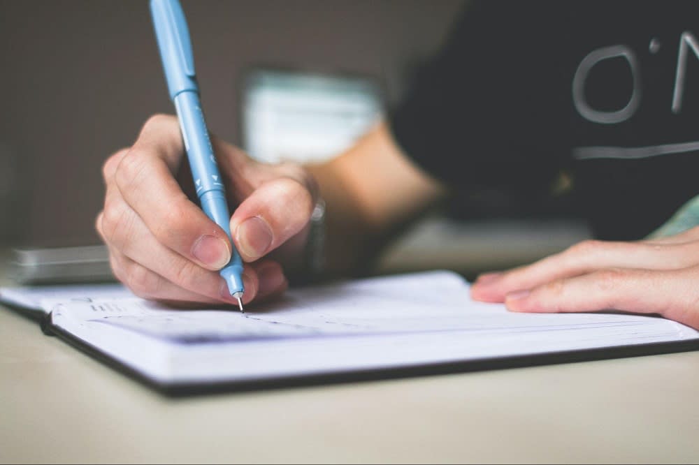 closeup of a person writing in a notebook