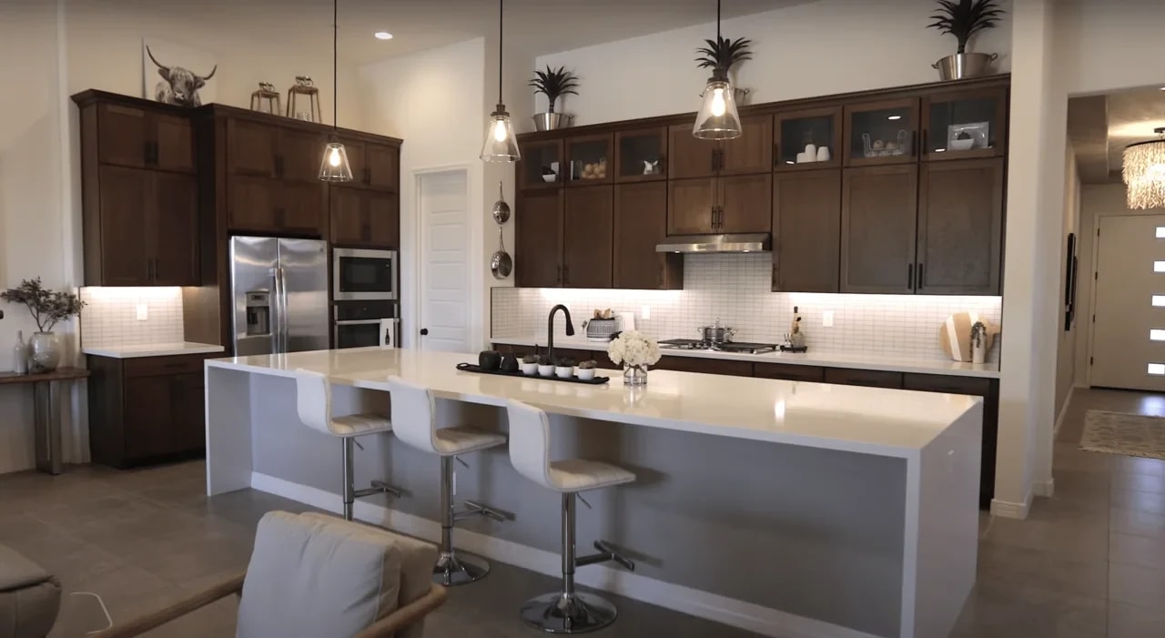 An inviting kitchen featuring a generously sized island and trendy bar stools.