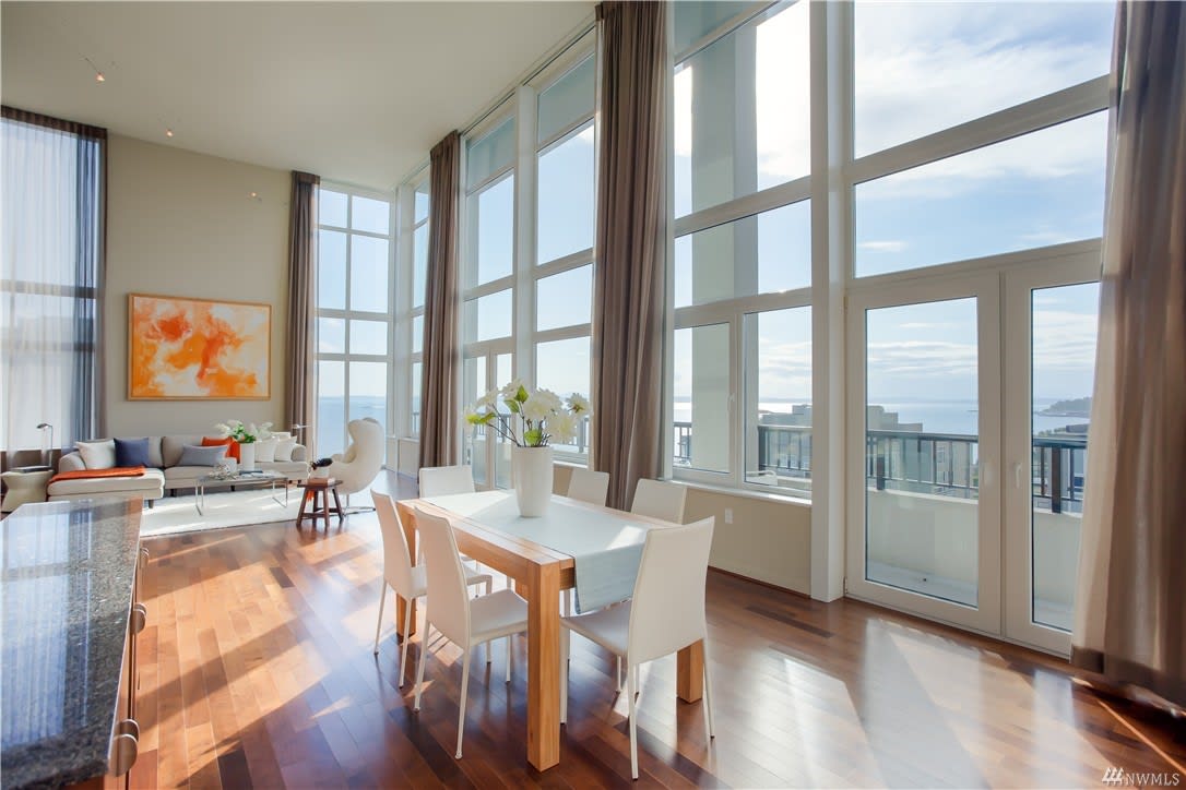 High-rise luxury condo dining and living space with floor-to-ceiling windows offering panoramic views.