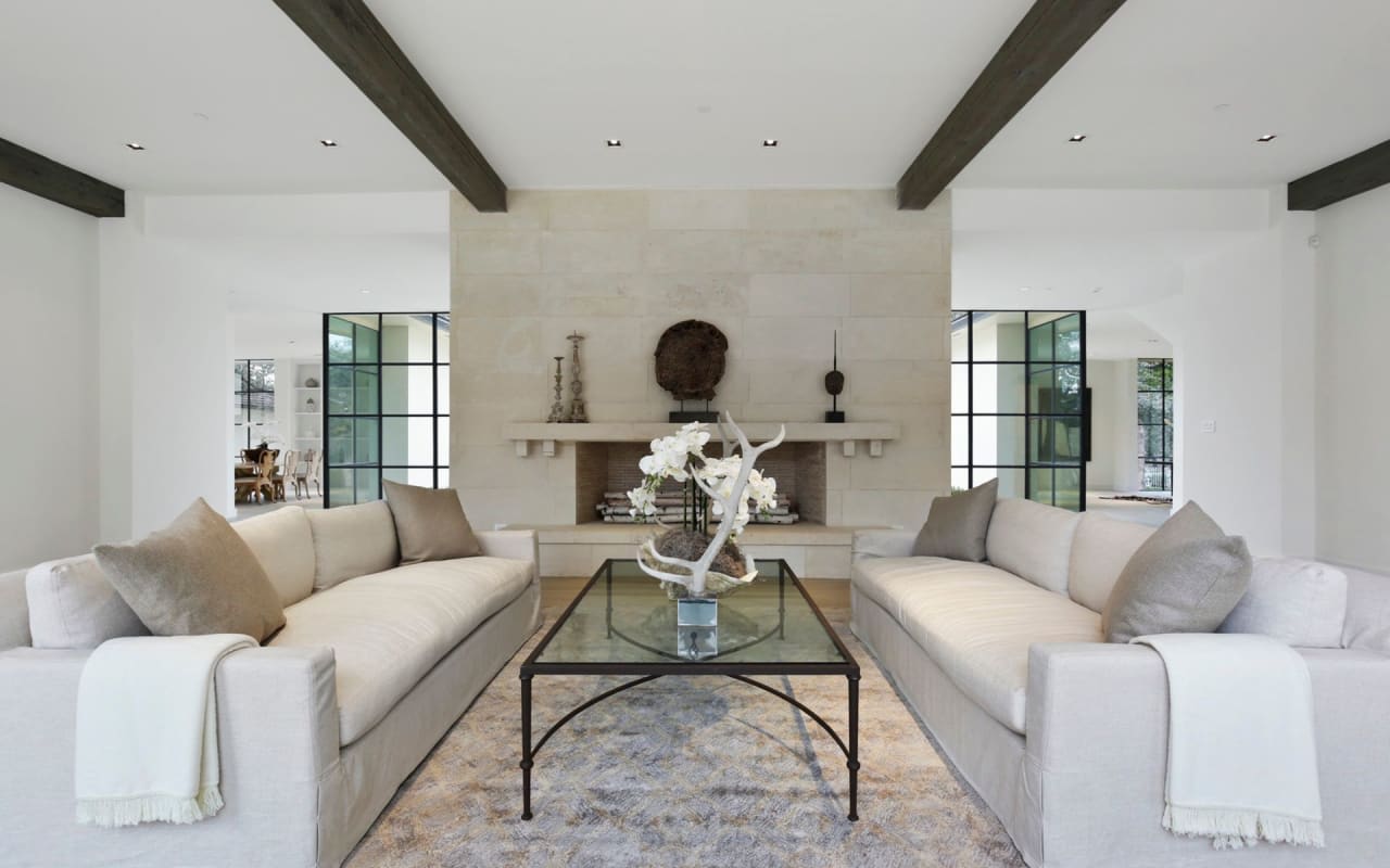 Inviting seating area in a spacious open space, featuring an oversized fireplace and large sofas for ultimate comfort.