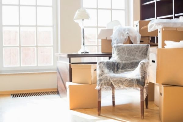 A room with moving boxes and furniture packed and ready for the moving van