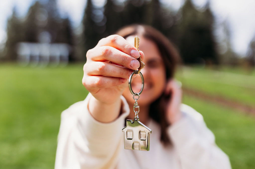 Samara Behler holds up keys to a first time home buyer's home in Spokane, WA