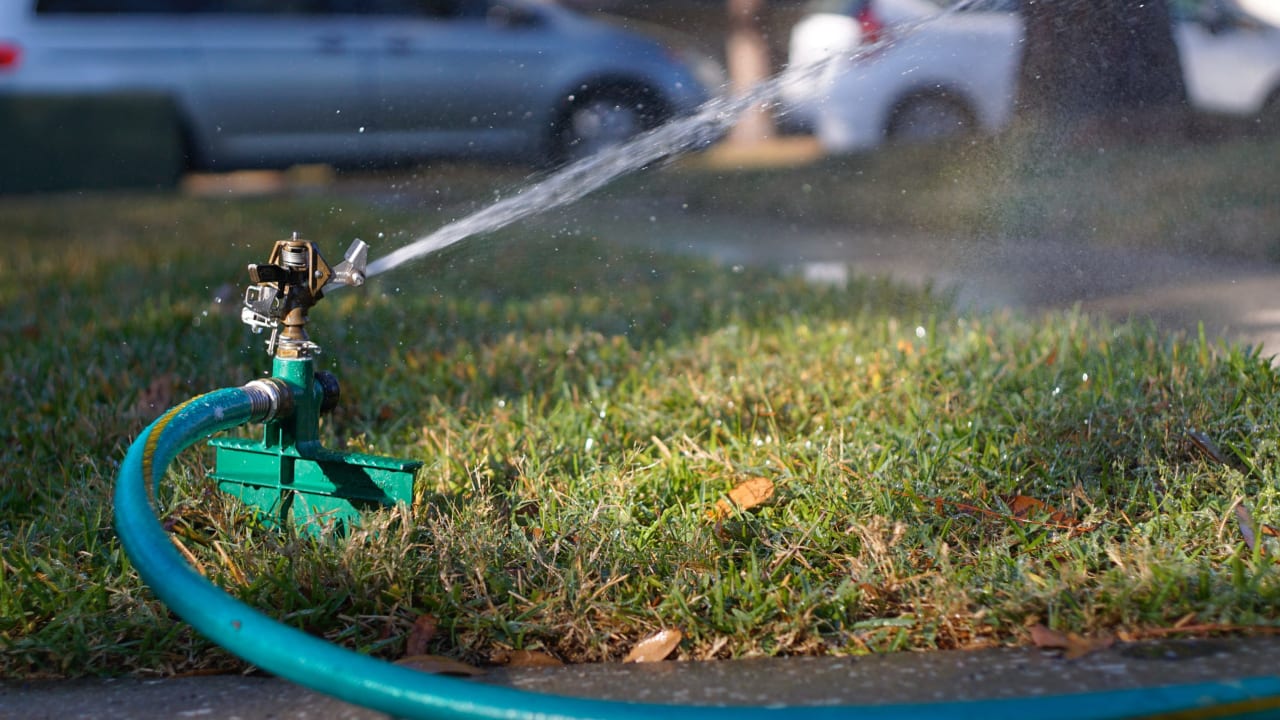 A sprinkler spraying water on a lawn.