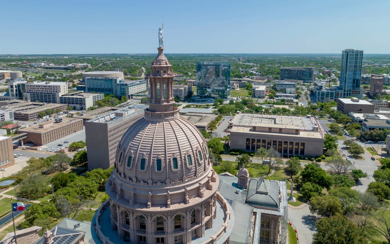 Aerial view of the U.S. Capitol Building's dome, with its intricate white cast iron ribs and Statue of Freedom