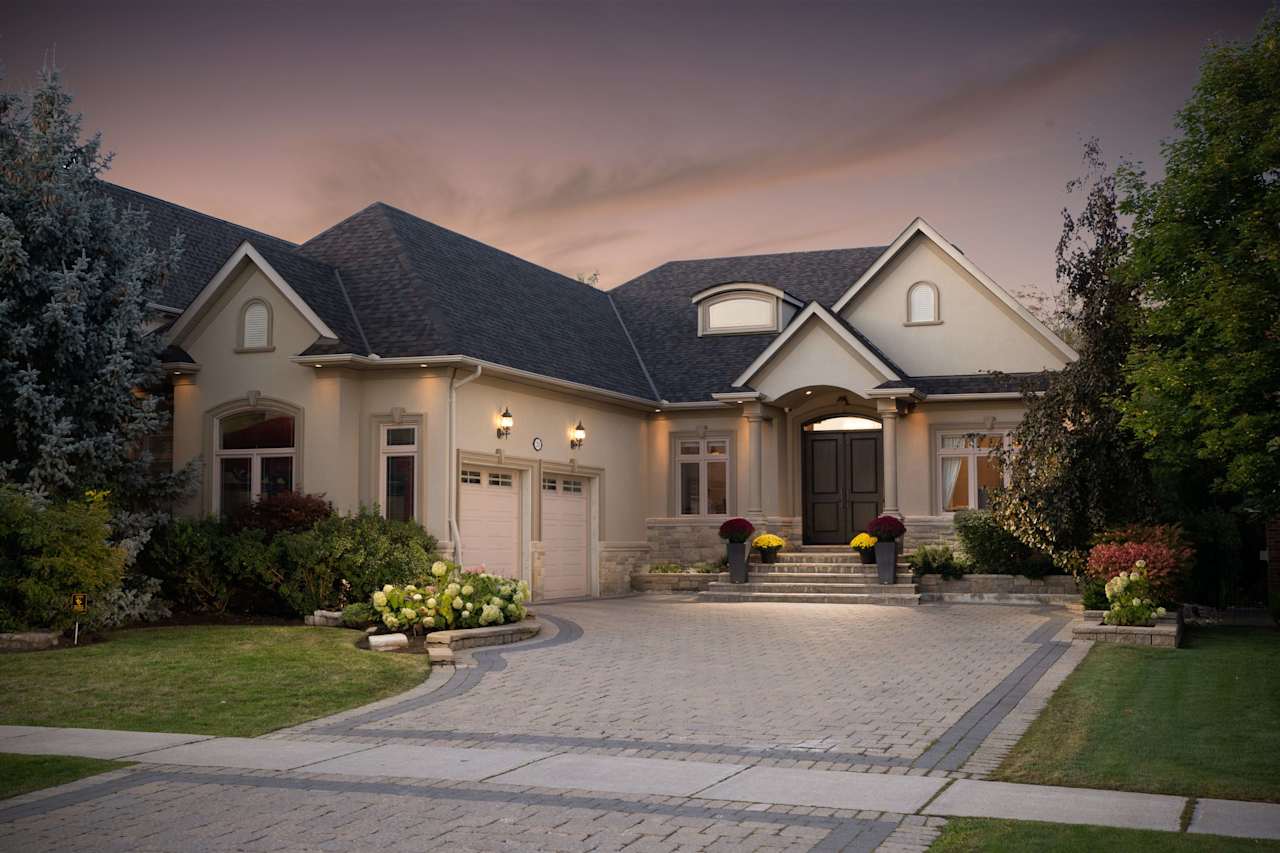 A modern house with a spacious driveway and a well-lit front porch