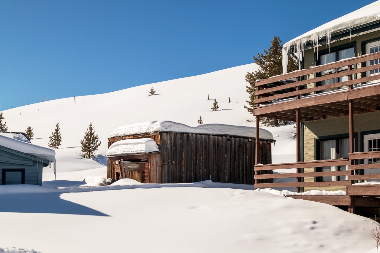 Two houses sitting on top of a snow-covered hill