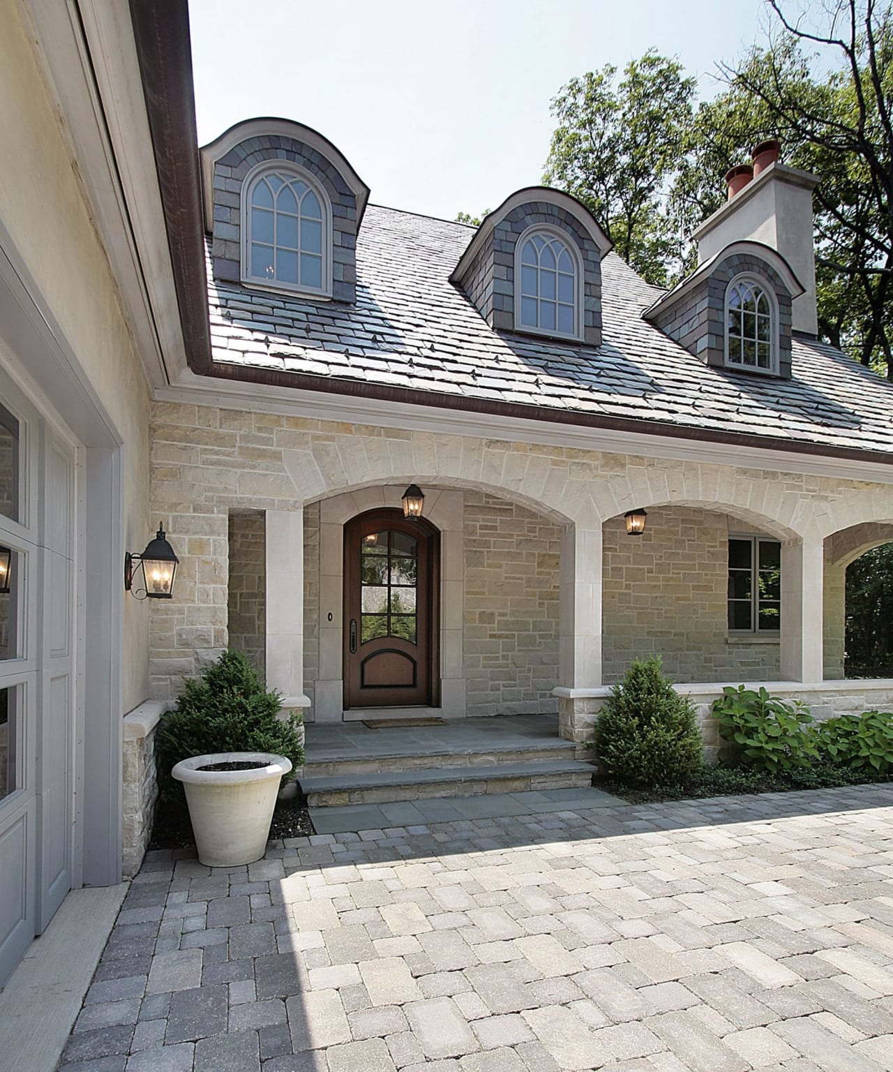 A traditional two-story house with a welcoming stone porch