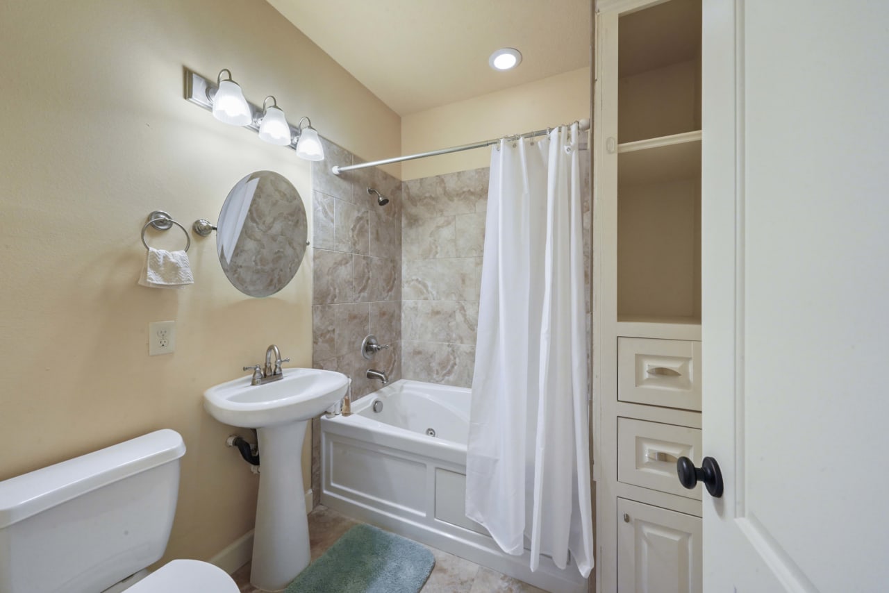 Ensuite bathroom to front bedroom with Juliet balcony. Great built-ins for linens and laundry hamper.