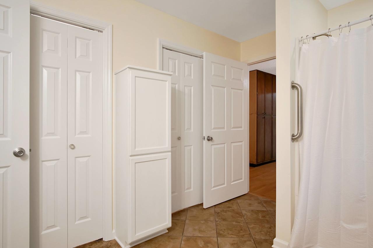 Photo of the primary bathroom featuring tan tiled floors