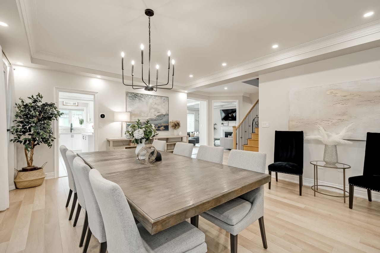 A dining room with a long wooden table and chairs with high backs.