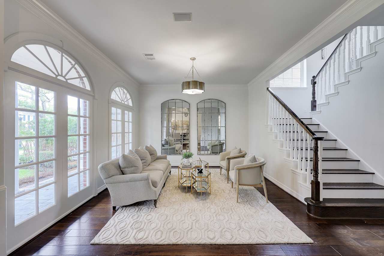 A living room with a plush, grey couch facing a wooden coffee table
