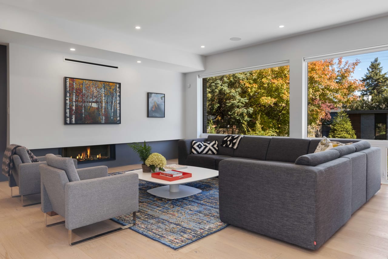 A cozy living room with grey couches and a white coffee table. 