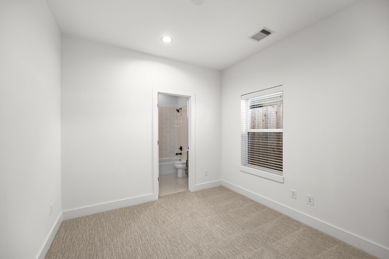 unfurnished guest bedroom with an ensuite bathroom