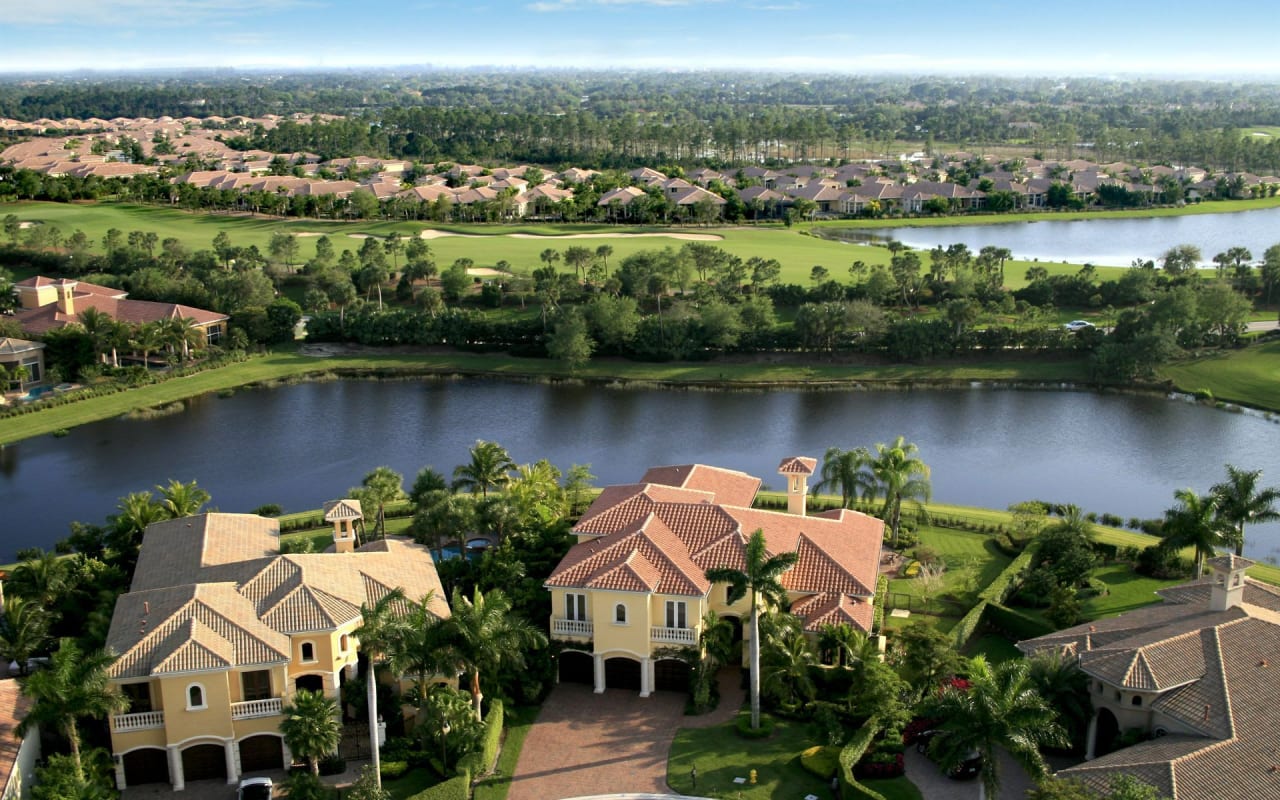 An aerial view of a residential area with a lake and a golf course.