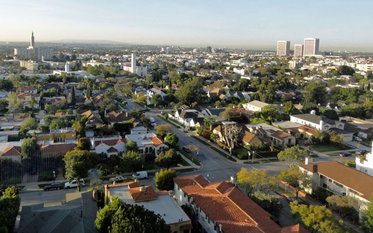 An affluent residential neighborhood with colorful homes, manicured lawns, and wide streets