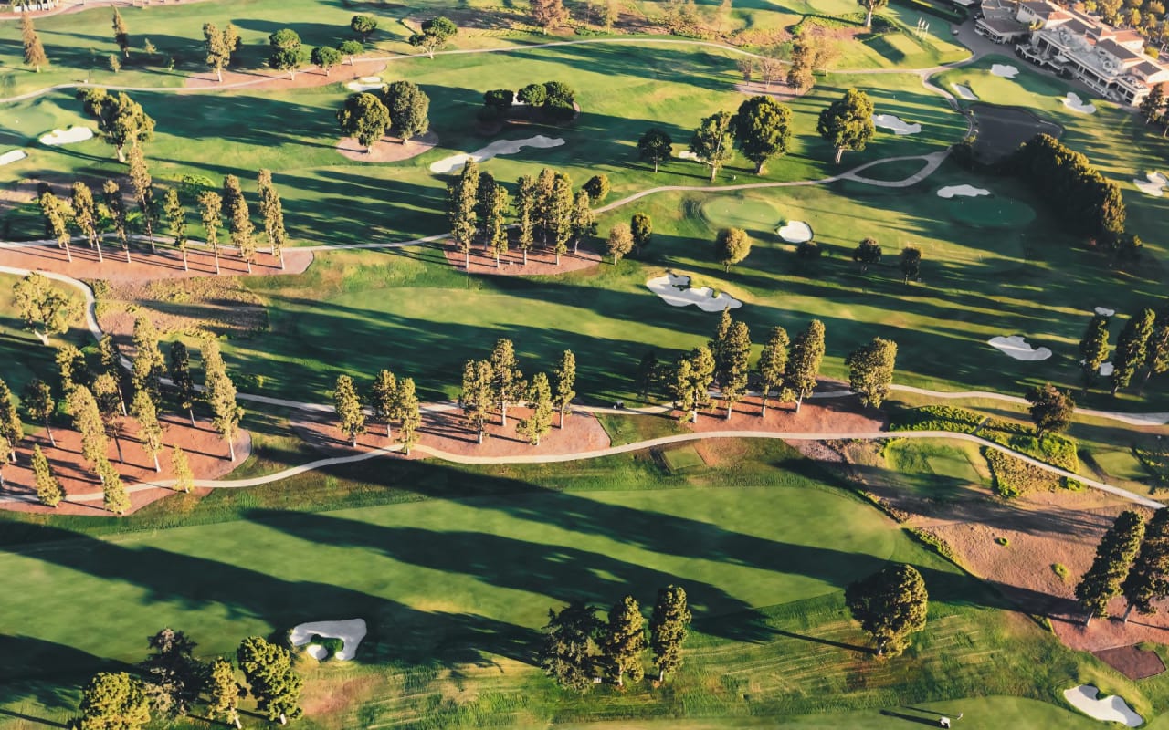 An aerial view of a golf course surrounded by trees