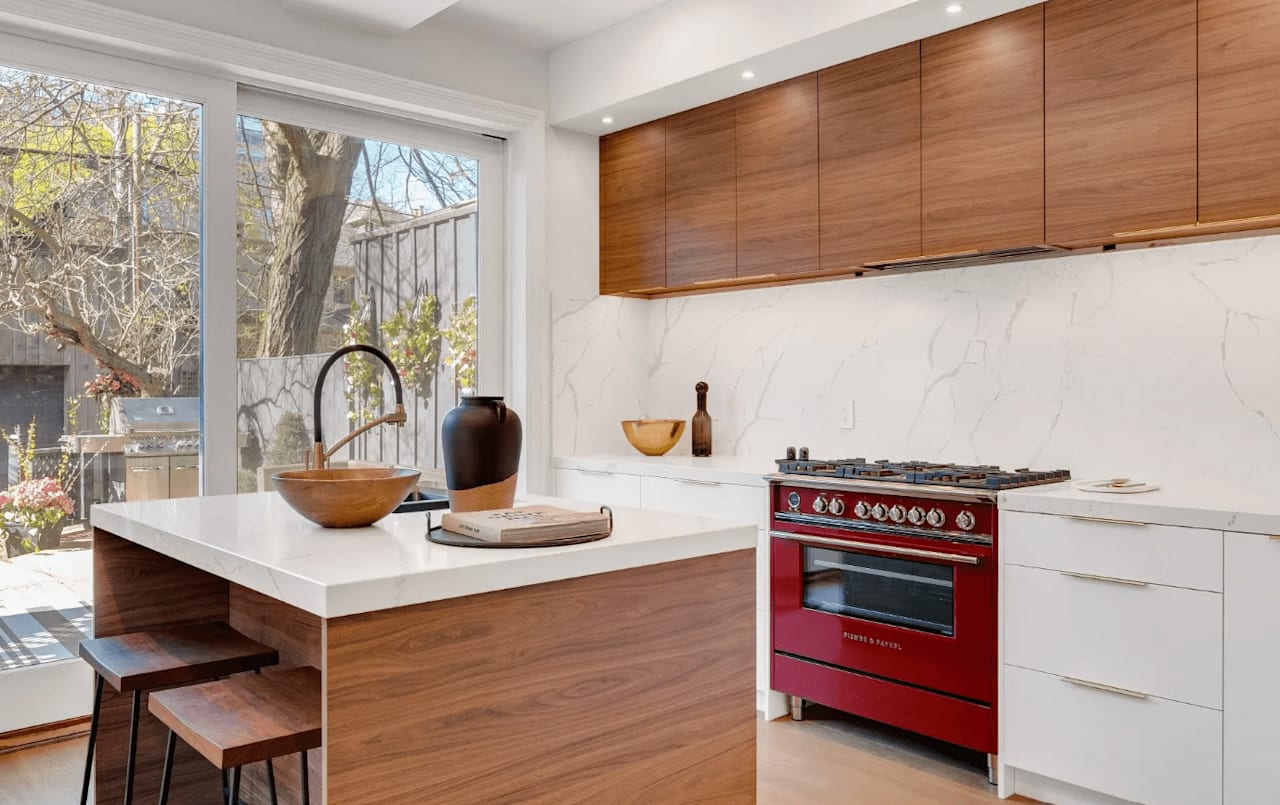 A bright and airy kitchen with a red oven and a wooden island. The wooden island adds a touch of warmth and personality.