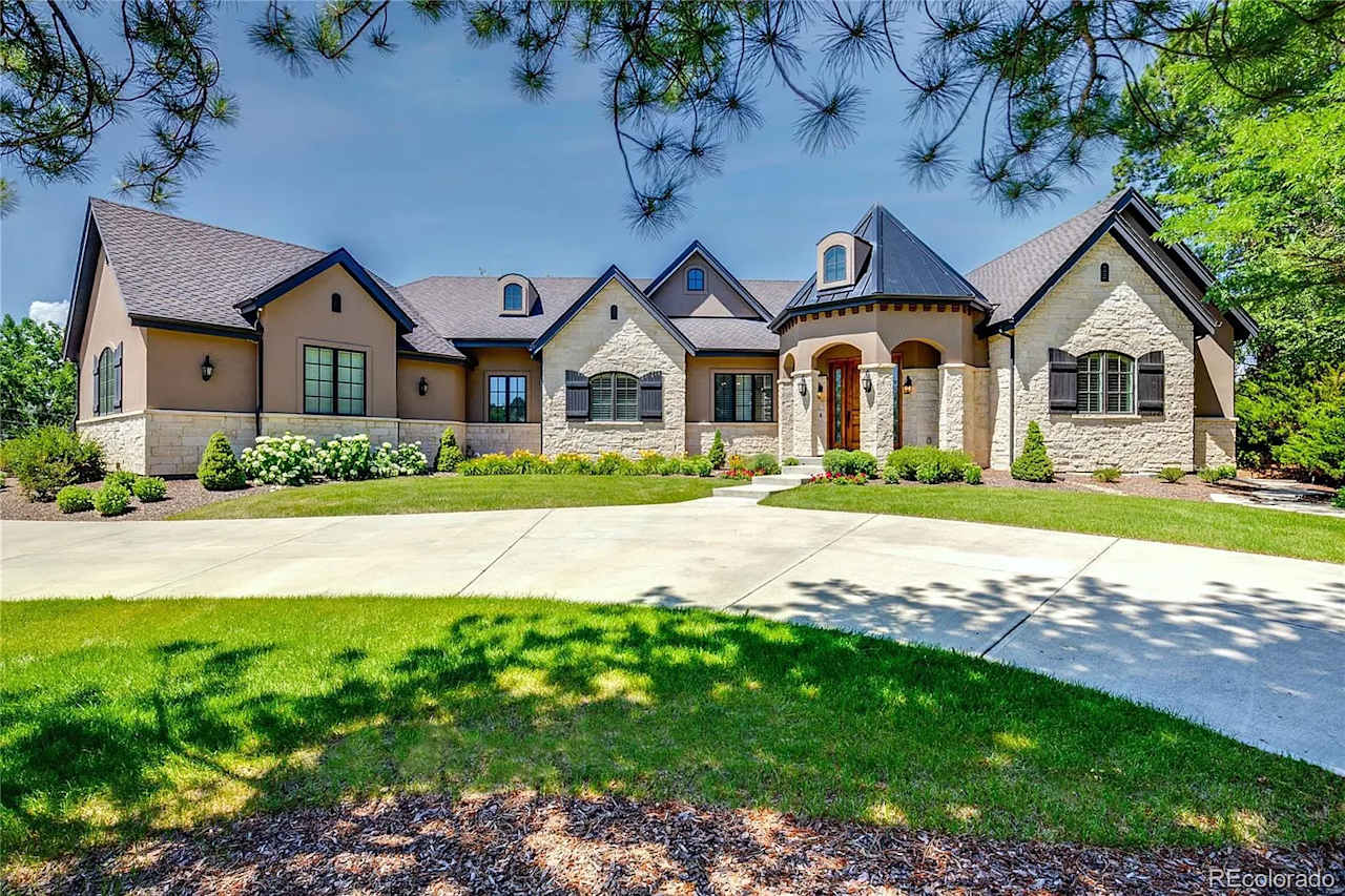 A large, two-story house with a stone exterior and a three-car garage 