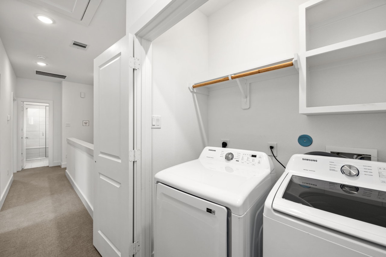 laundry room with white shelves 