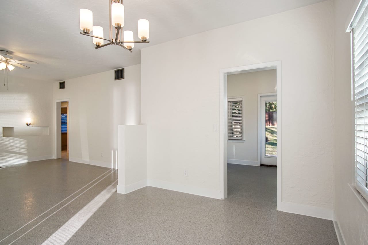 A view of the kitchen entrance, highlighting the open layout leading to other rooms. The space is bright with modern light fixtures.