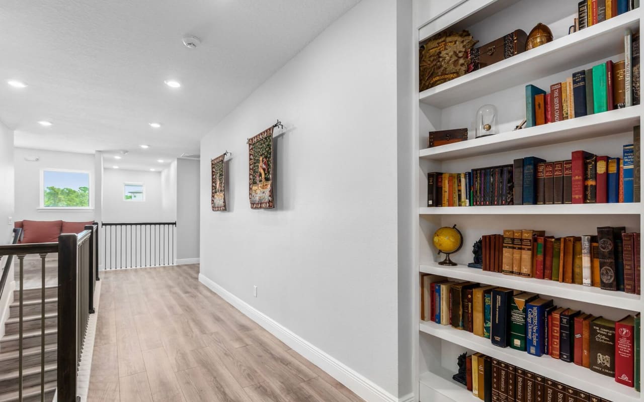 A long hallway with a floor-to-ceiling bookshelf on one wall.