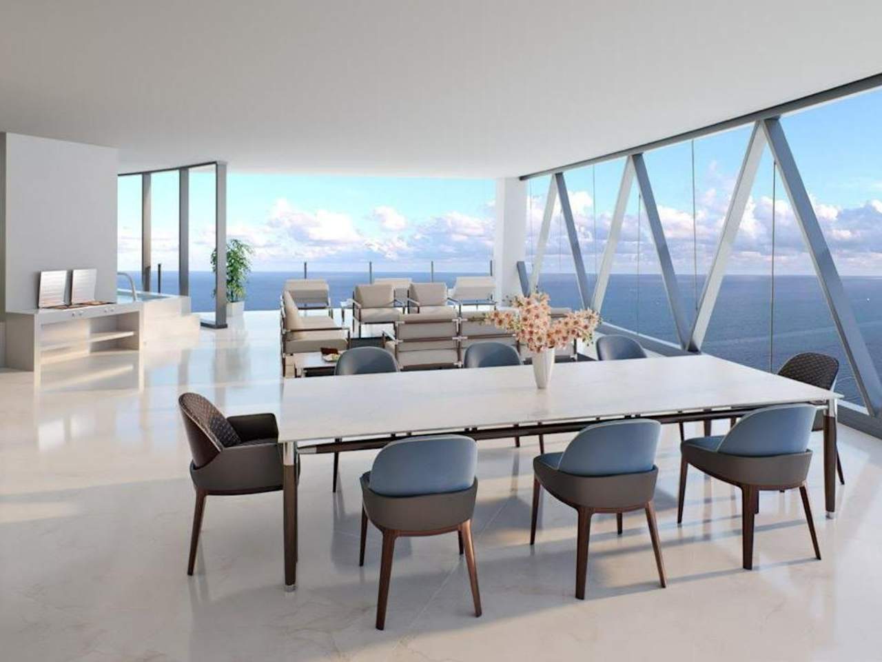 Luxury condo dining area with modern seating and floor-to-ceiling windows overlooking the ocean.