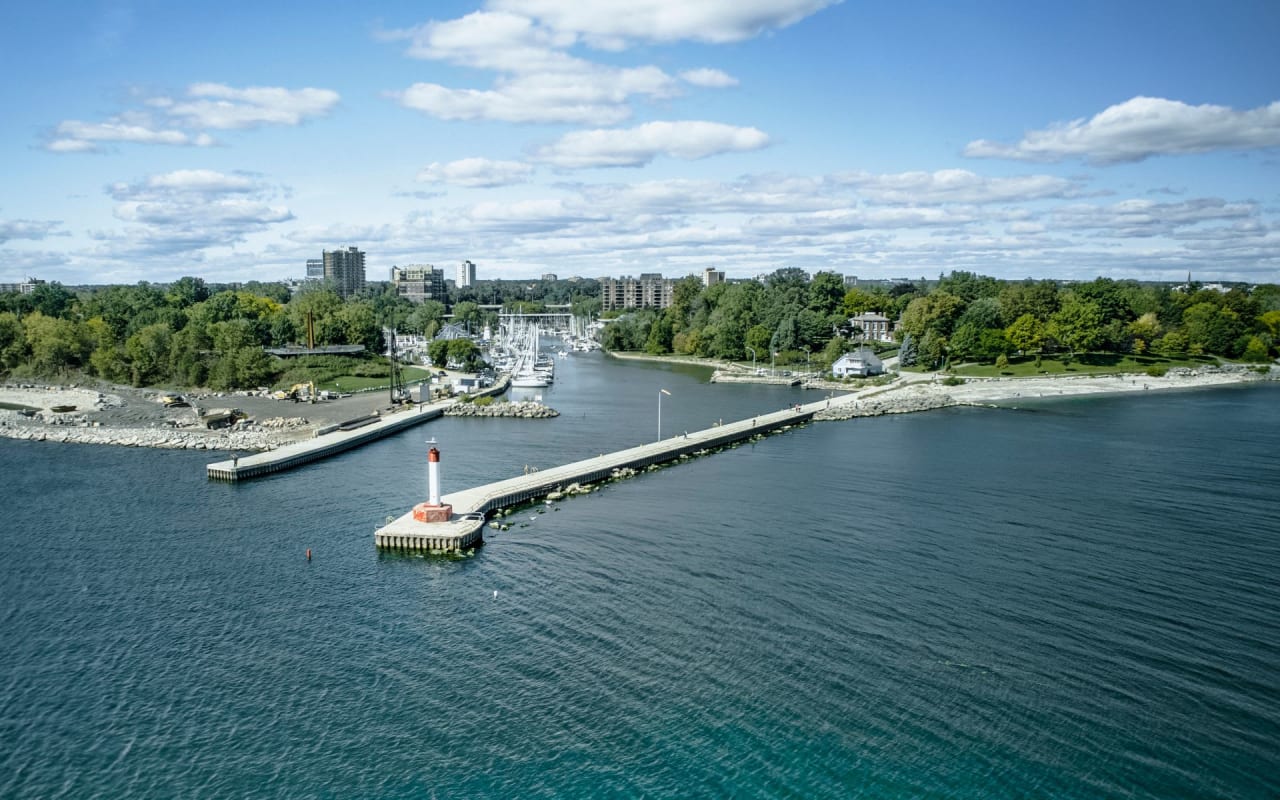 A lighthouse on a pier jutting out into a body of water.