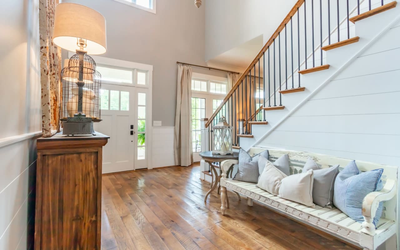 Image of a white bench next to a staircase with a dark wood banister