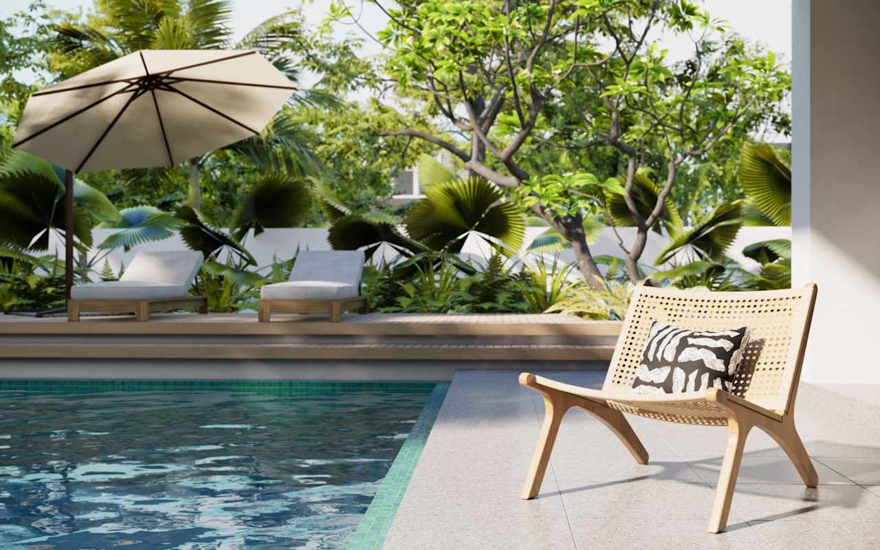 Outdoor pool patio with tropical landscaping, loungers, umbrella, and woven chair.