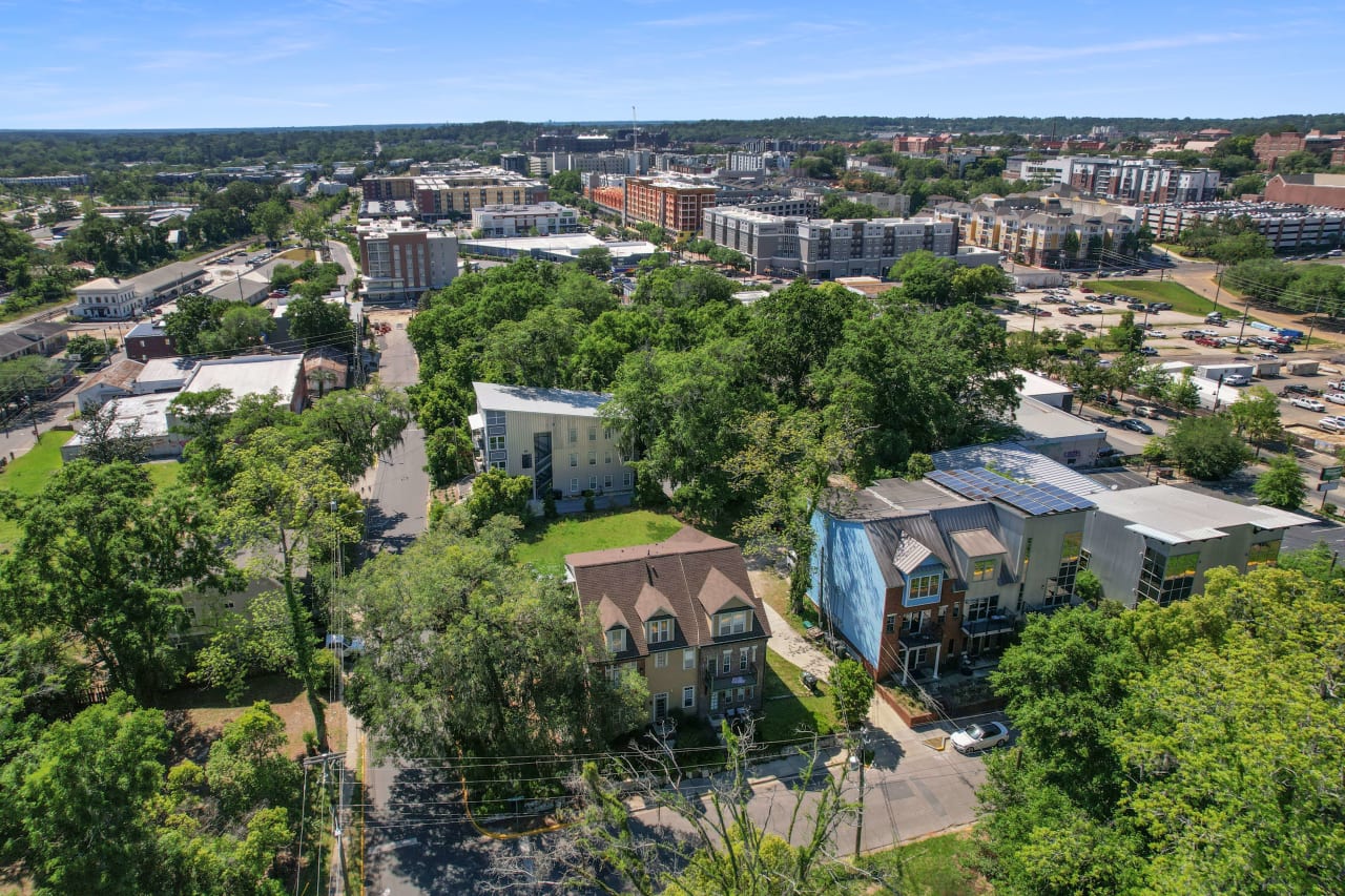 Another aerial view of All Saints, showcasing the layout of buildings, streets, and surrounding greenery in a dense urban setting.