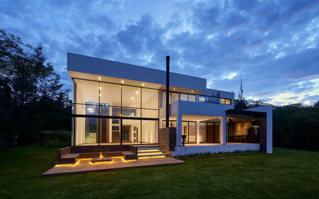 A modern house with large windows illuminated from the inside.