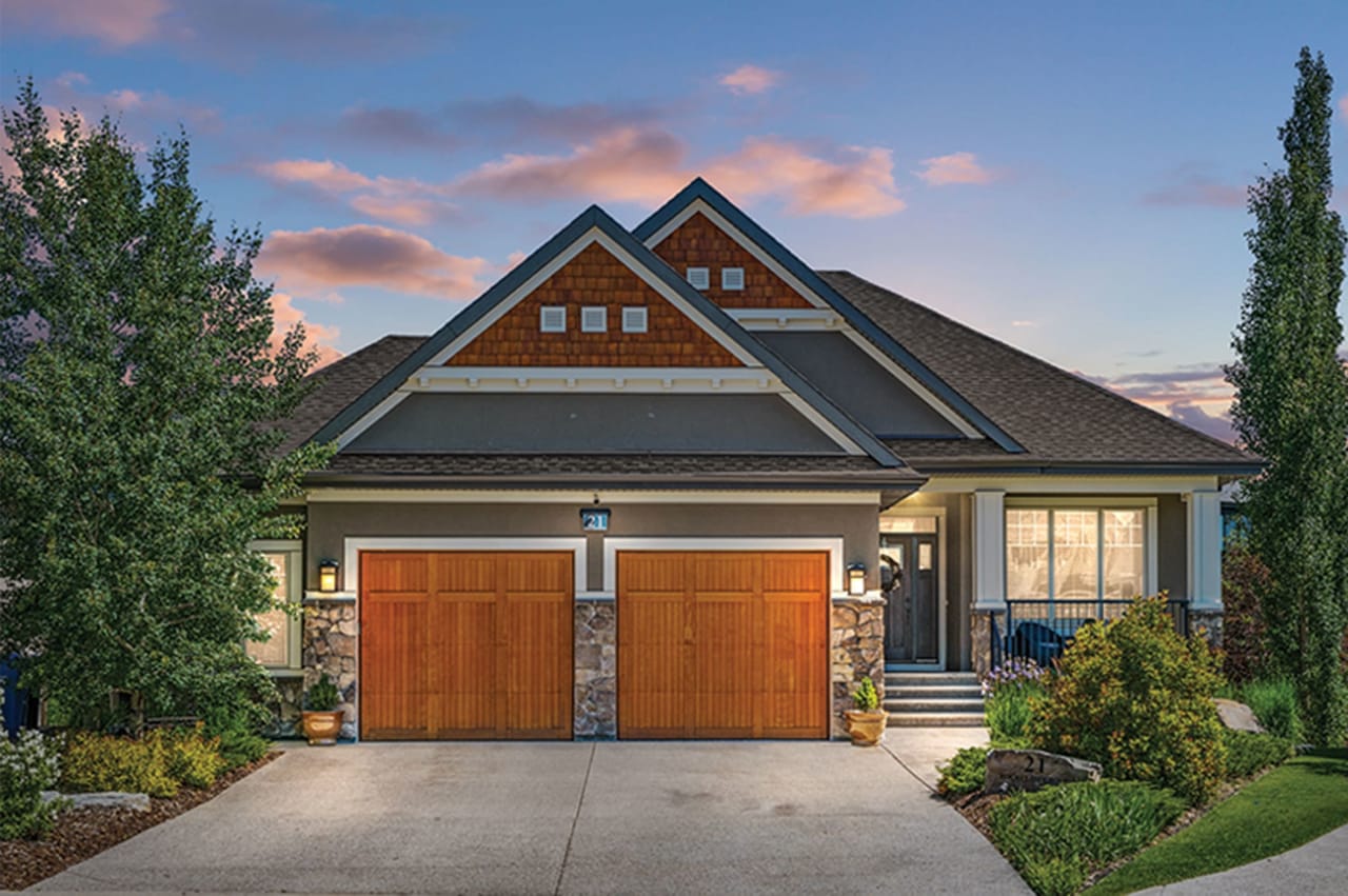 A modern house with two garage doors and a red brick roof