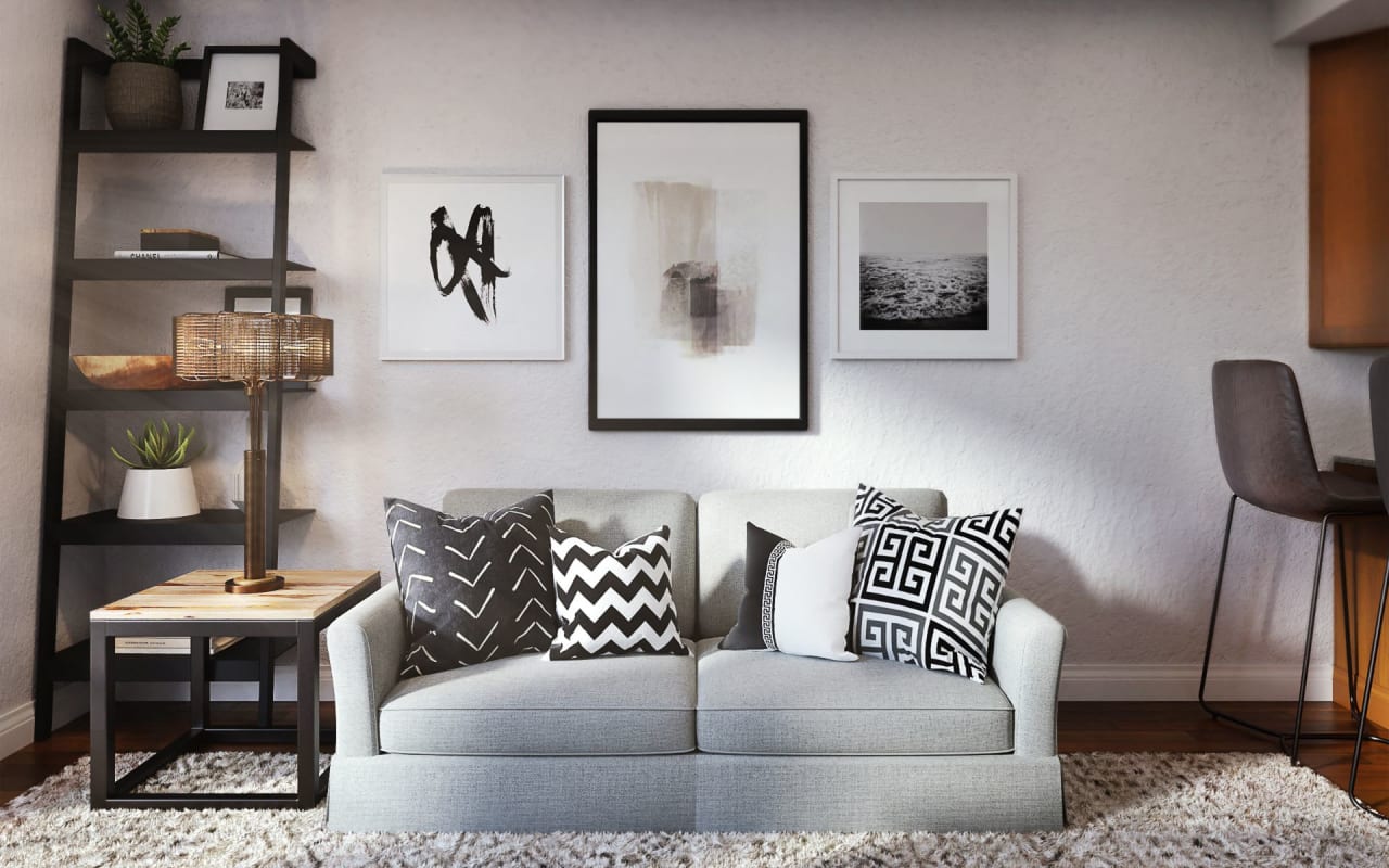 A modern living room with a couch, a leaning ladder, a small side table, a lamp, and some framed artwork on the wall.