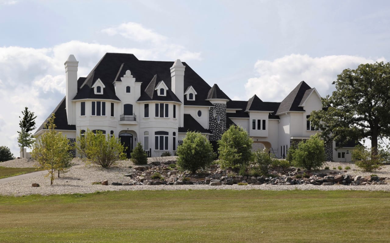 A grand white house with a black slate roof