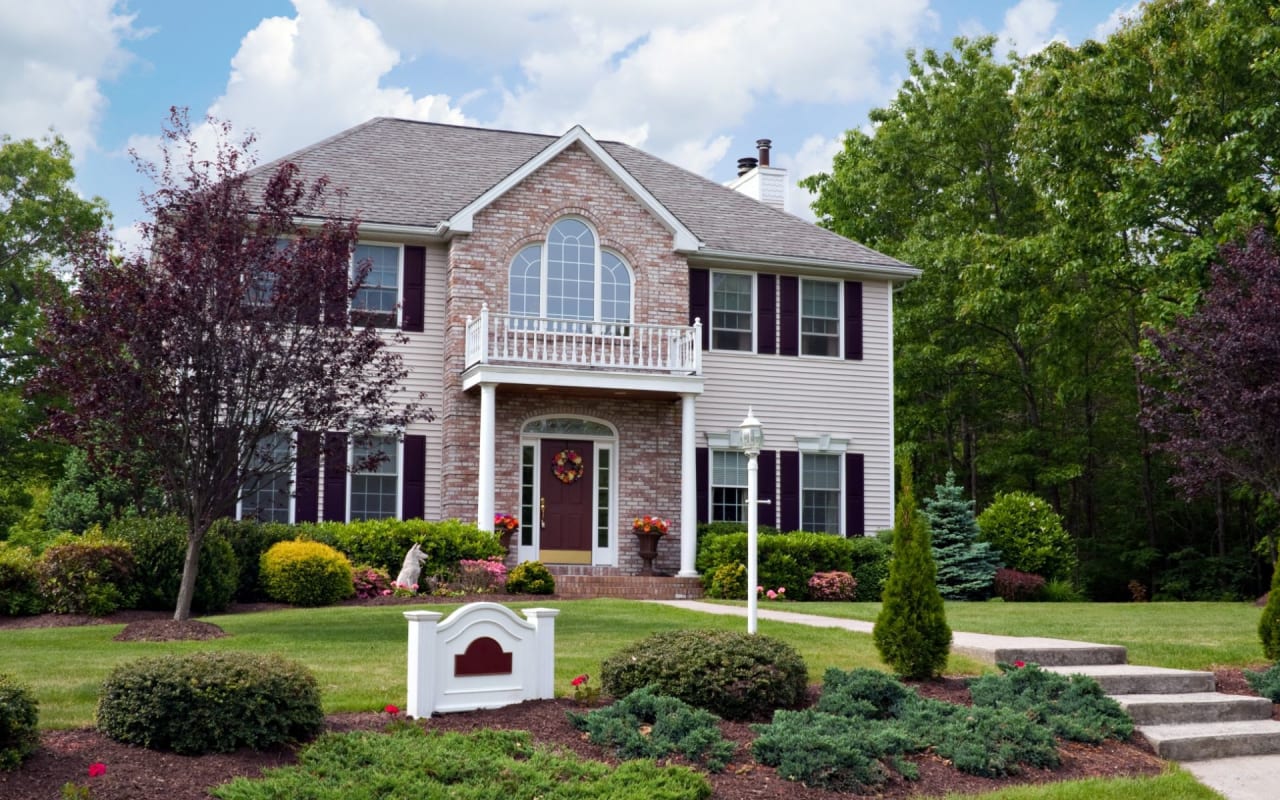 Large two-story brick house with balcony.