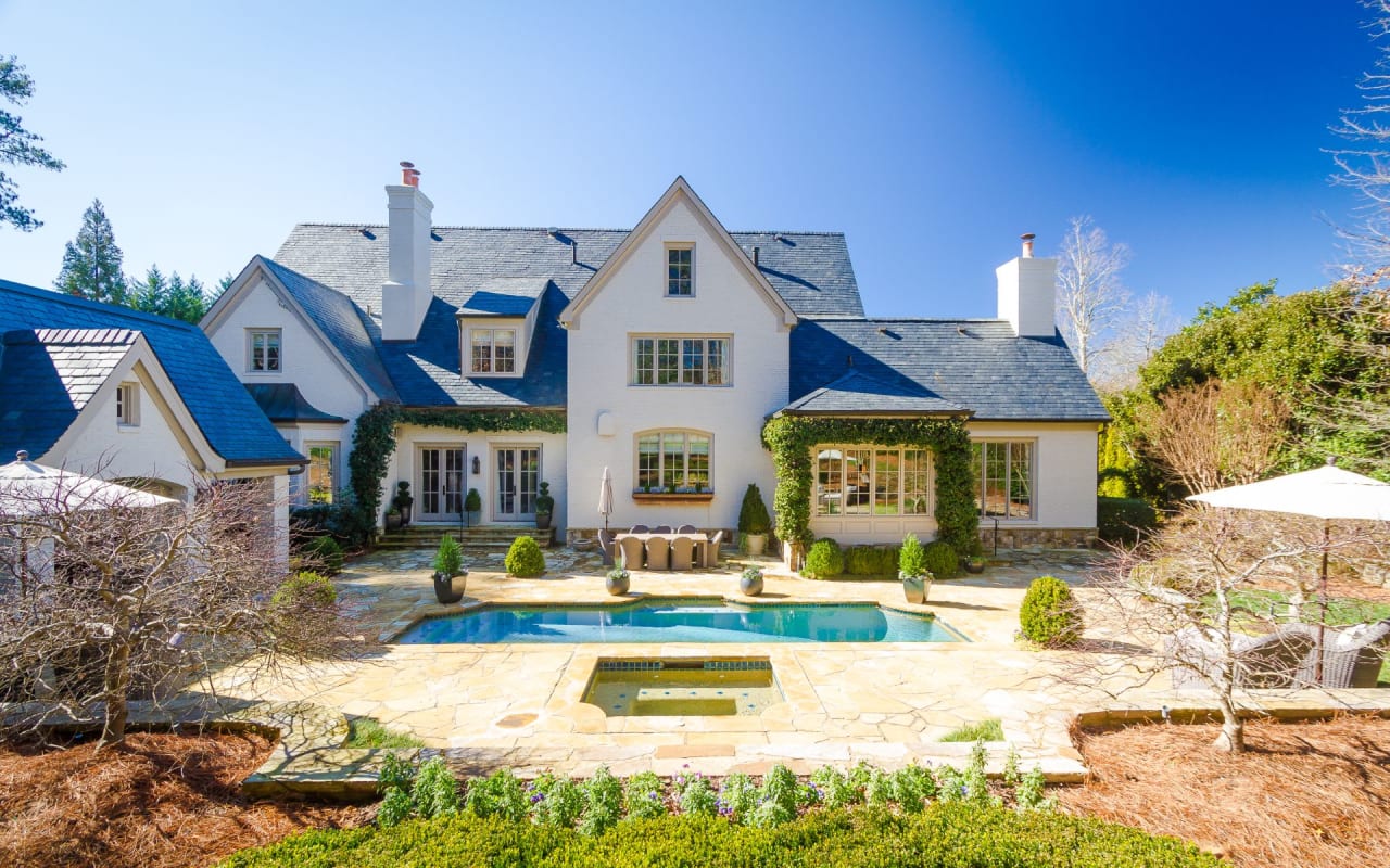 A large white house with a swimming pool in the backyard