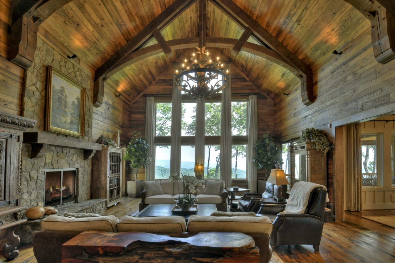 Living room with furniture including a brown leather couch, two armchairs, and a fireplace. 