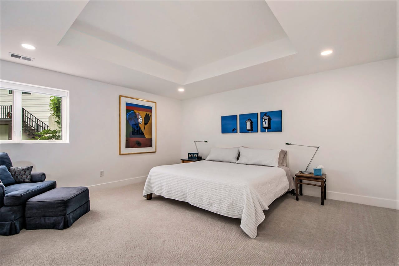 large room with bed and blue couch