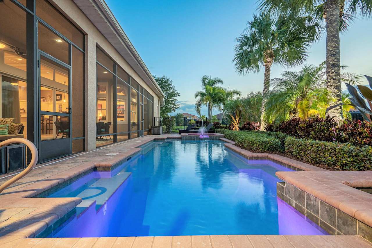 A serene and inviting pool area nestled within a beautifully landscaped backyard with a spacious patio.