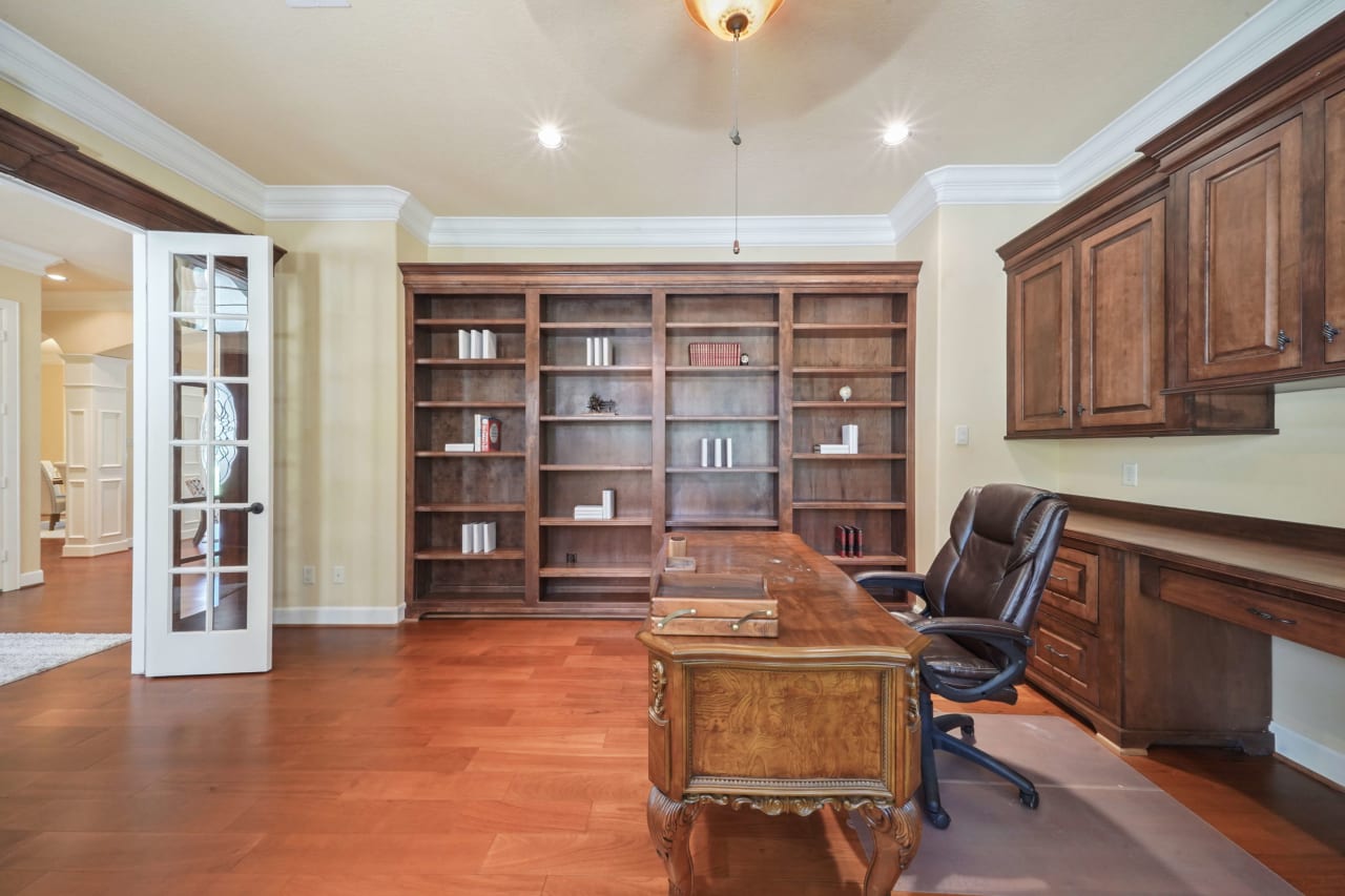 The study is finished with custom shelving and cabinetry and French doors for privacy! The bay window in this room provides natural light and a great view of the expansive front yard with large trees....