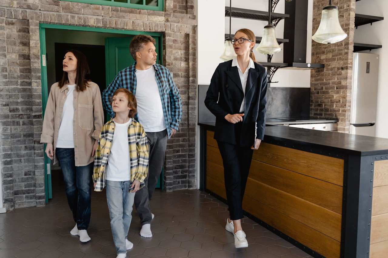 Two boys and two girls enter a brick home looking inside.