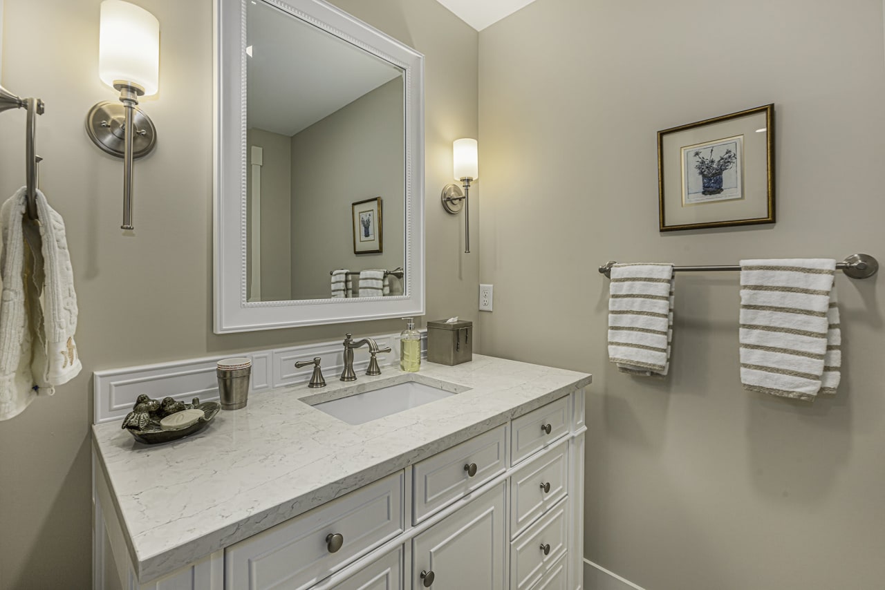 bathroom sink with mirror and a flower frame