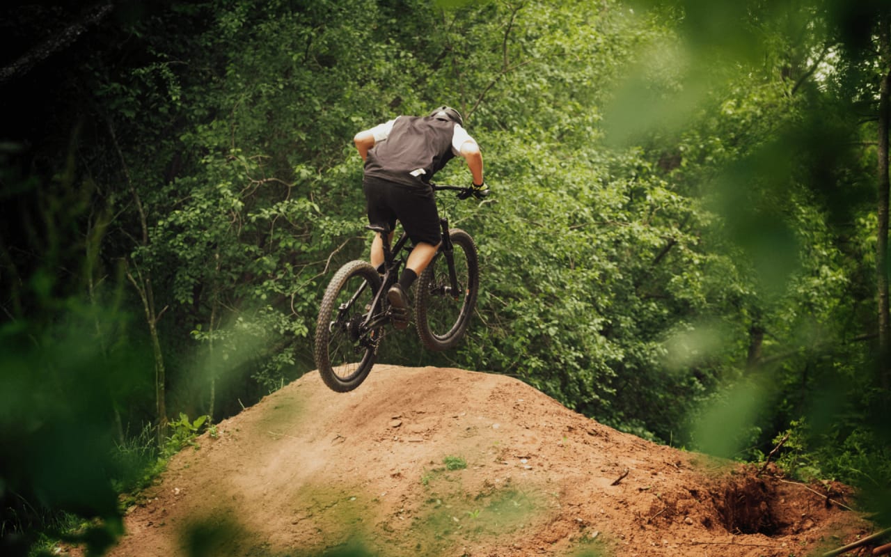 A cyclist riding a mountain bike on a dirt trail.