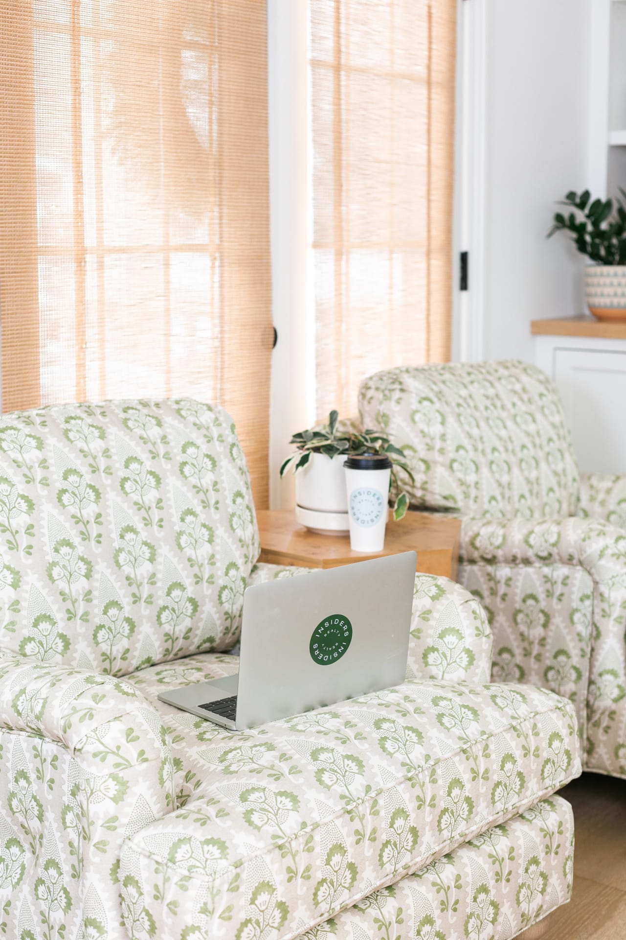 A laptop computer is open on a chair in a living room.