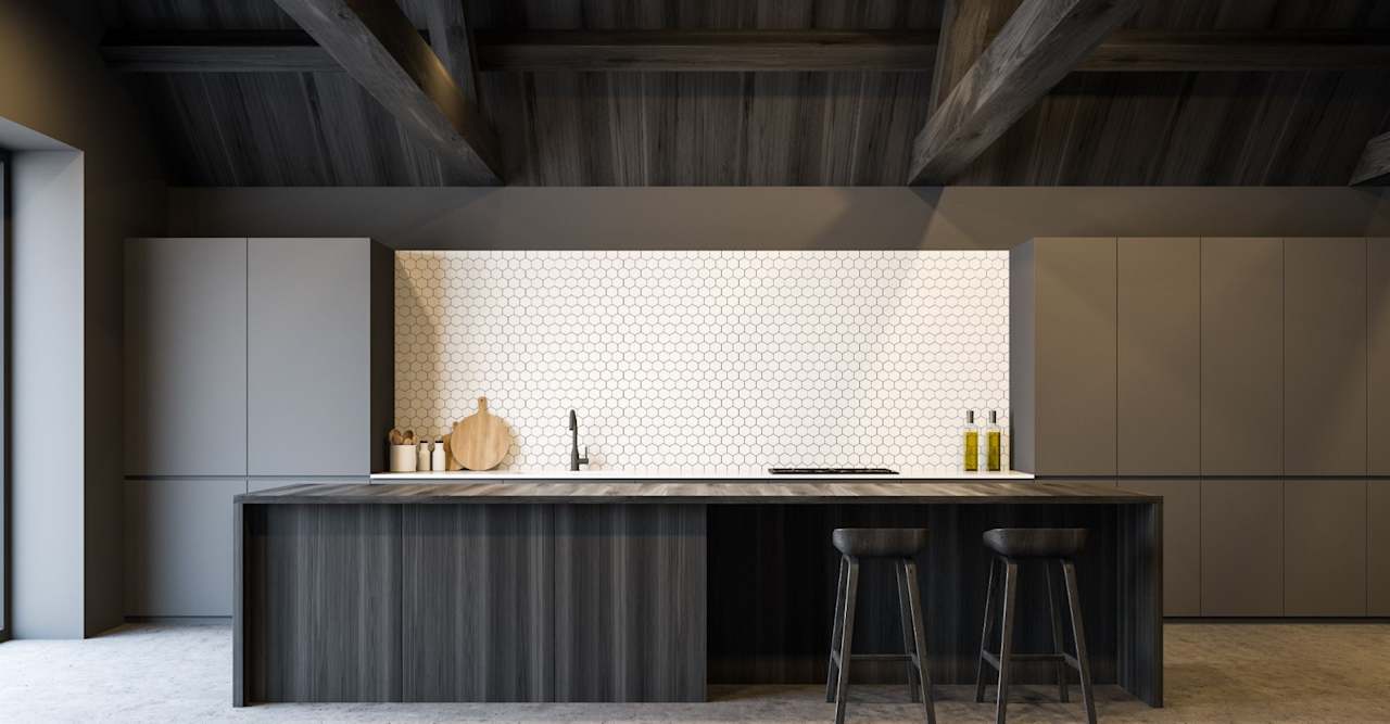 Modern kitchen with a dark wood island, two stools, white hexagonal backsplash, and exposed ceiling beams.